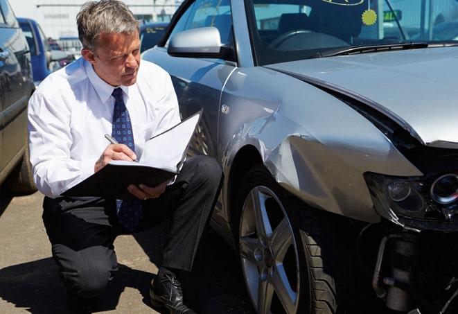 auto insurance policy document and pen on table